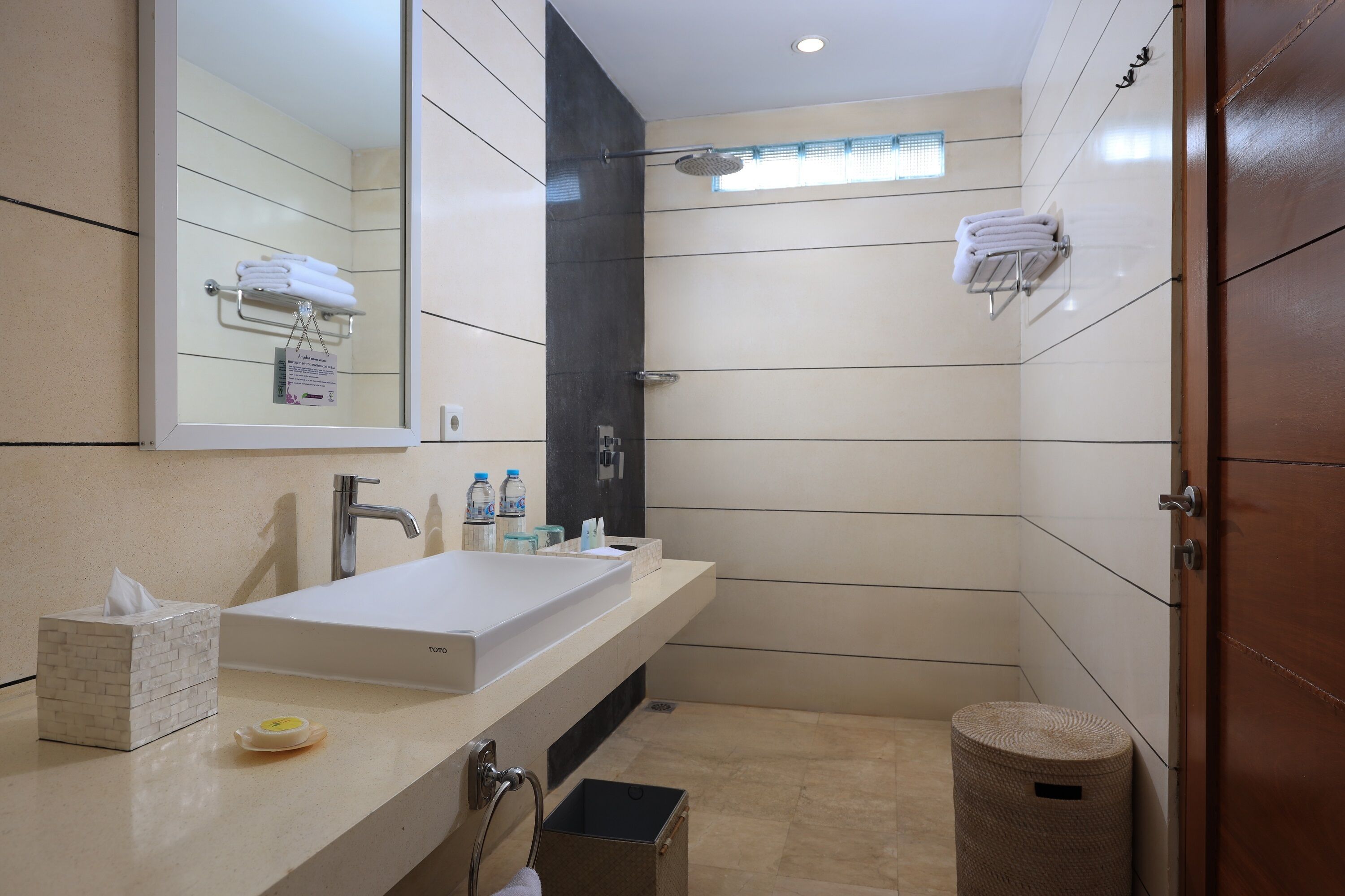 A modern bathroom with a large sink, mirror, and a shower area.