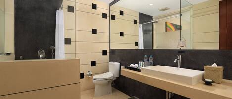 A modern bathroom with a large mirror, a white sink, a toilet, and a shower.