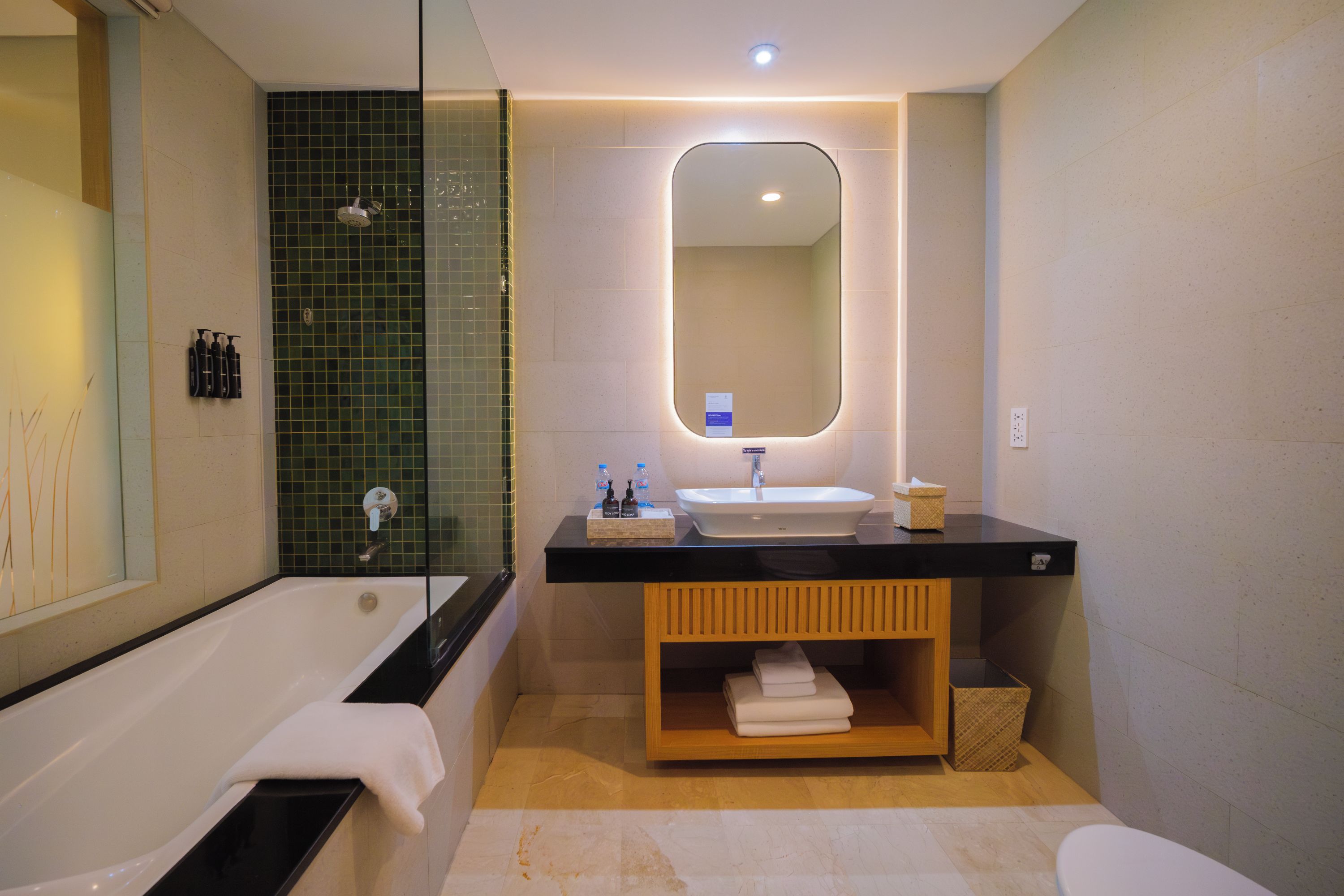 A modern bathroom with a bathtub, a glass-enclosed shower, a vanity with a sink, and a mirror.