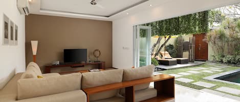 Una sala de estar moderna con un sofá, televisor y una mesa de centro de madera.