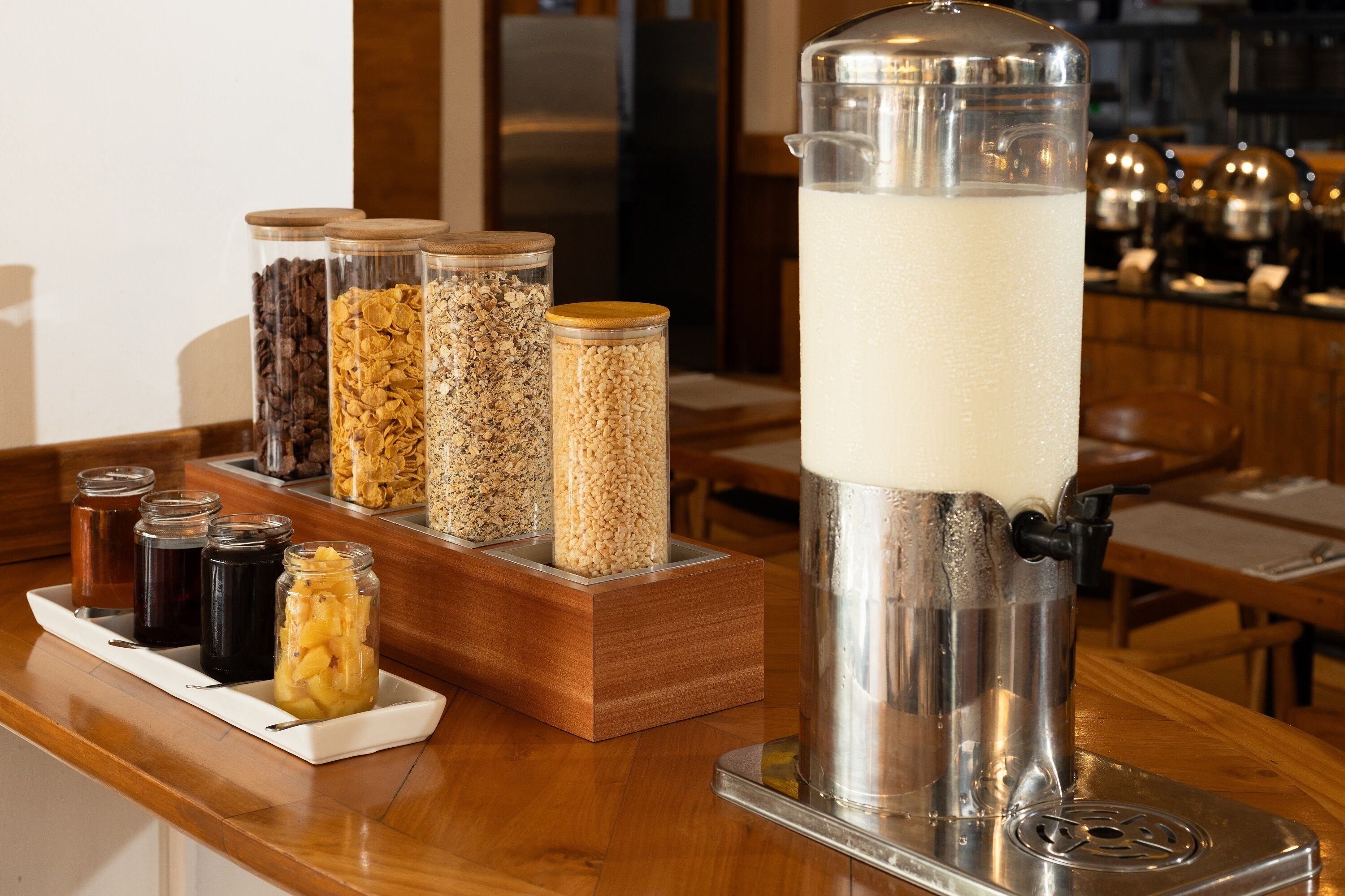A coffee station with various containers of coffee beans and a milk frother.