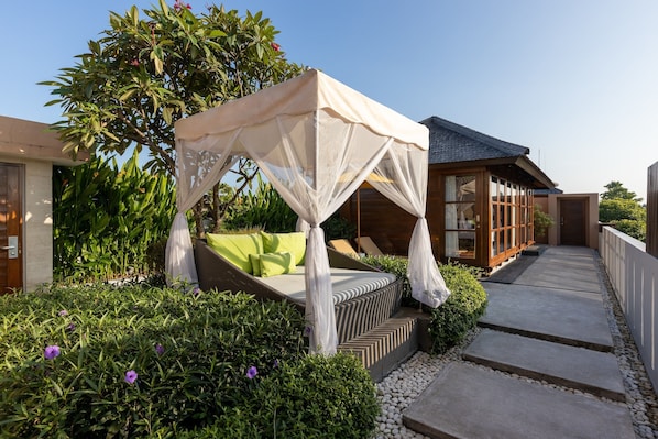 Um jardim com uma cama de dossel, uma estrutura de madeira e um caminho.