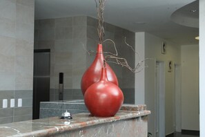 Bathroom features a marble countertop, two vases, and a shower area.