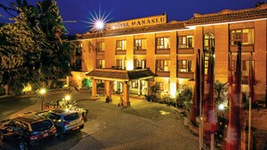 Hotellin edessä on kyltti, jossa lukee ”HOTEL MANASLJU”. Hotellissa on perinteinen arkkitehtoninen tyyli, useita parvekkeita ja kivetty sisäpiha.