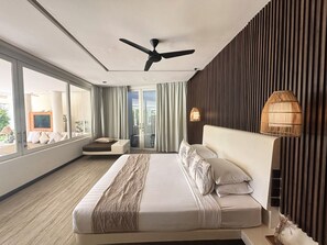 A modern hotel room with a large bed, a ceiling fan, a view of the outdoors, and a large window. -  Eden The Residence at The Sea Seminyak (Seminyak)