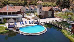 Un complexe hôtelier doté d’une piscine, de chaises longues et d’une tour.