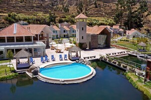 Um resort com piscina, espreguiçadeiras e uma torre.