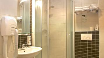 A modern bathroom with a glass-enclosed shower, a white sink, and a toilet.