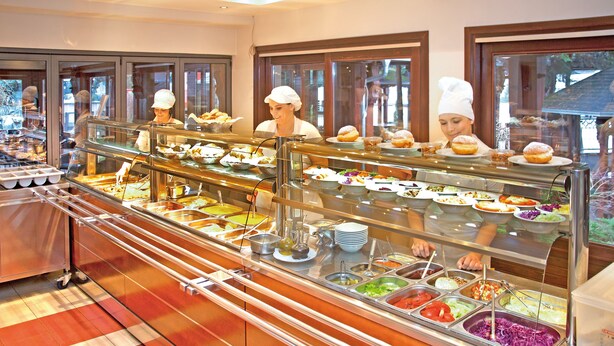 A buffet with various food stations and staff serving.