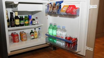 Un refrigerador abierto lleno de bebidas y aperitivos.