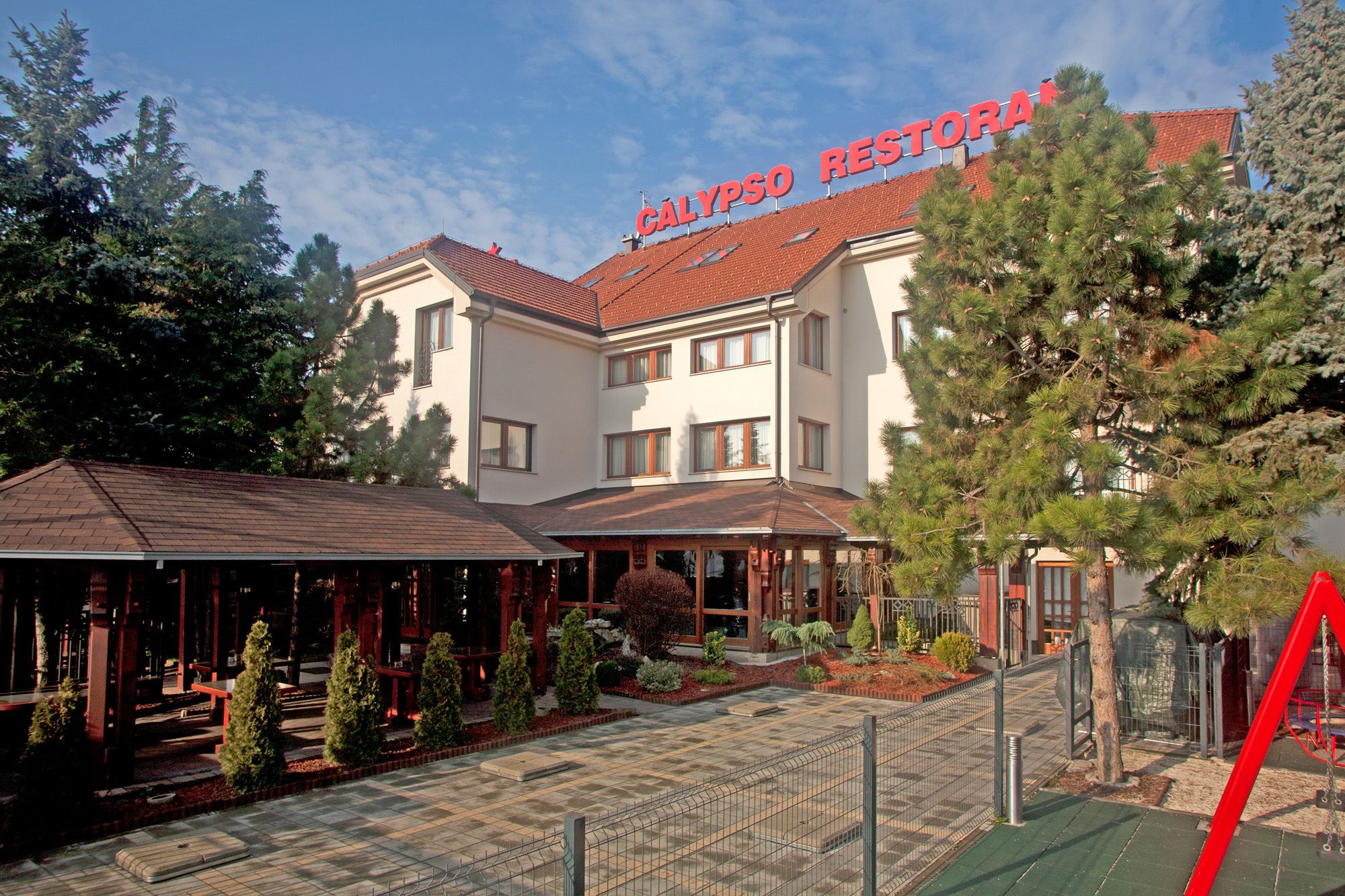 Un hôtel dont le toit porte une enseigne indiquant : « RESTAURANT CALYPSO ».