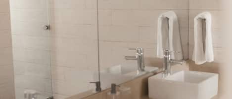 Een moderne badkamer met twee wasbakken, een grote spiegel en een handdoekdispenser.