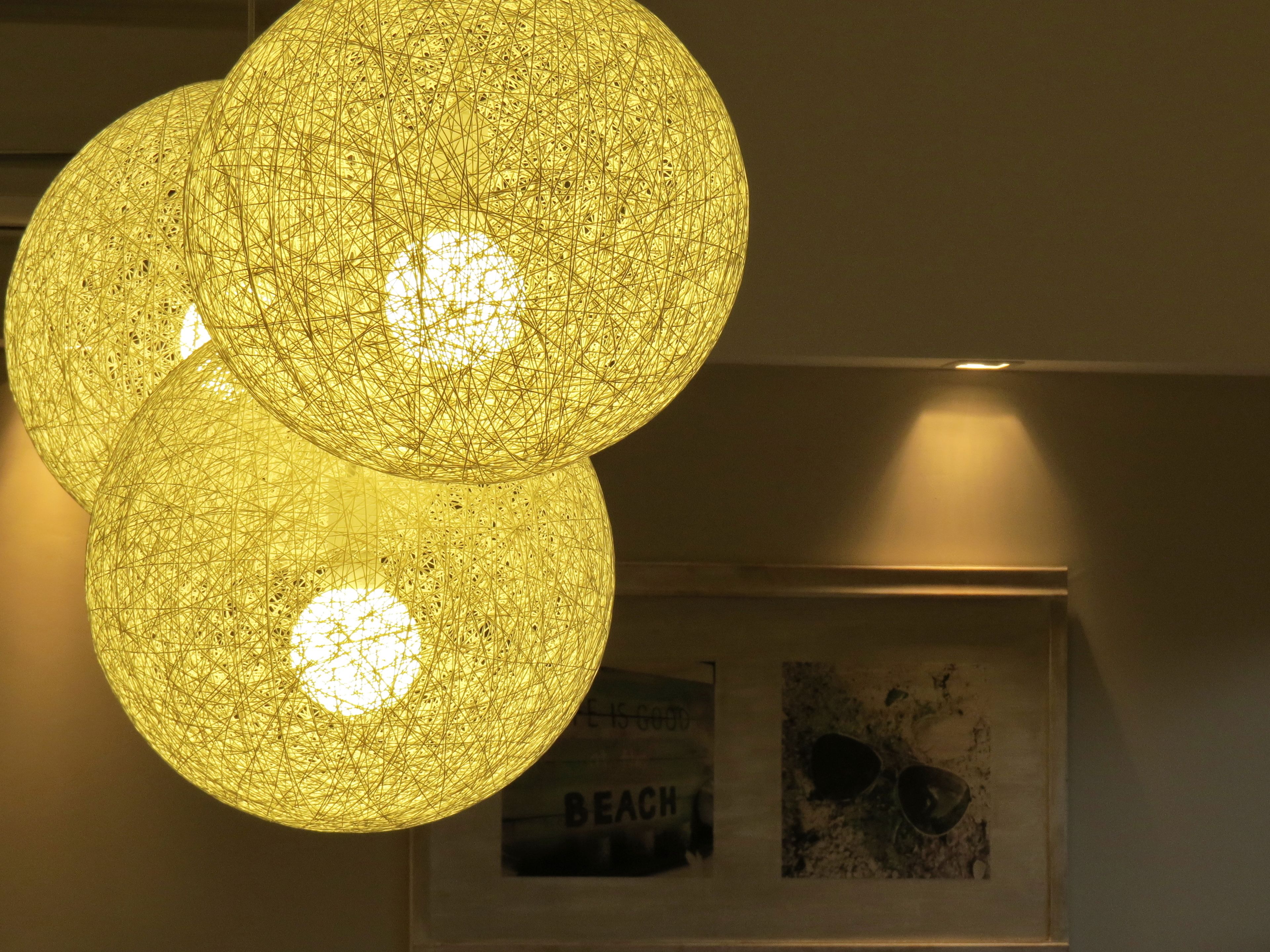 A spherical, intricately woven light fixture with a warm glow.