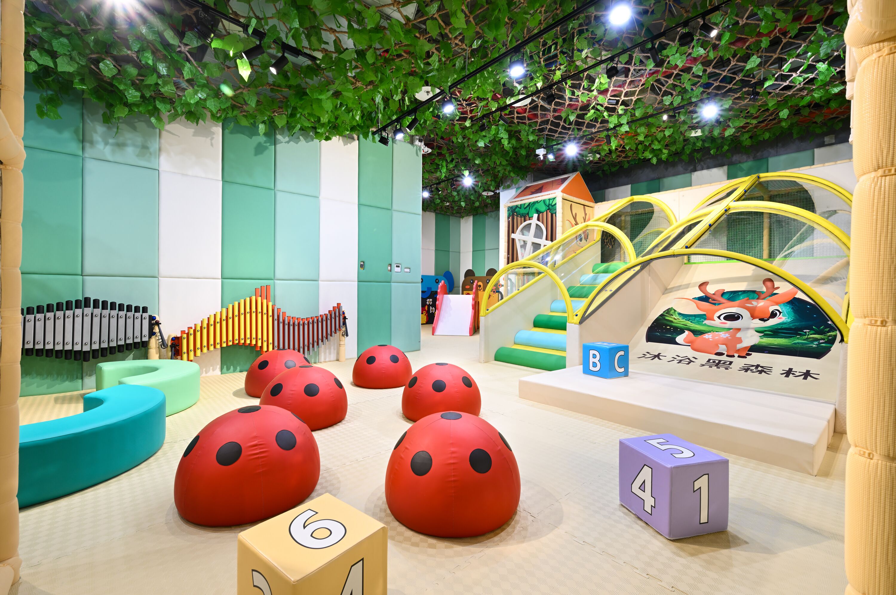 A children's play area with soft play structures, a slide, and a climbing net.