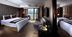A hotel room with two beds, a TV, a table with fruit and wine, and a balcony with curtains. - Sun Moon Lake Hotel (Yuchi)
