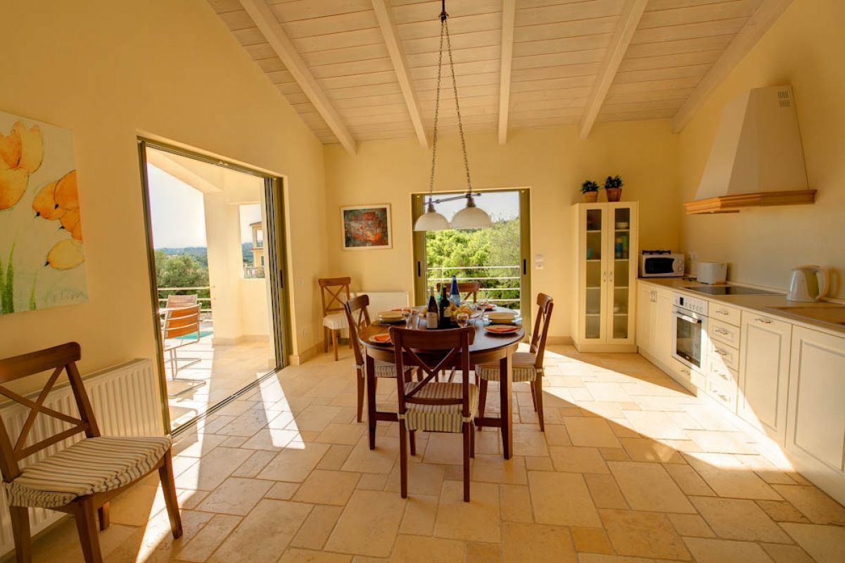 A dining area with a round table, chairs, and a view of the outdoors.