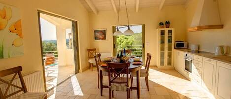 A dining area with a round table, chairs, and a view of the outdoors.