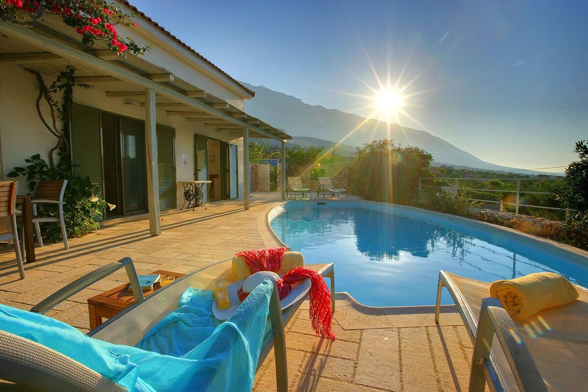 A poolside area with lounge chairs and a covered patio.