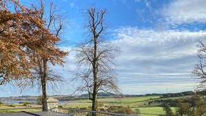 An outdoor patio with wicker furniture and a view of a rural landscape. - Balmule House (Dunfermline)