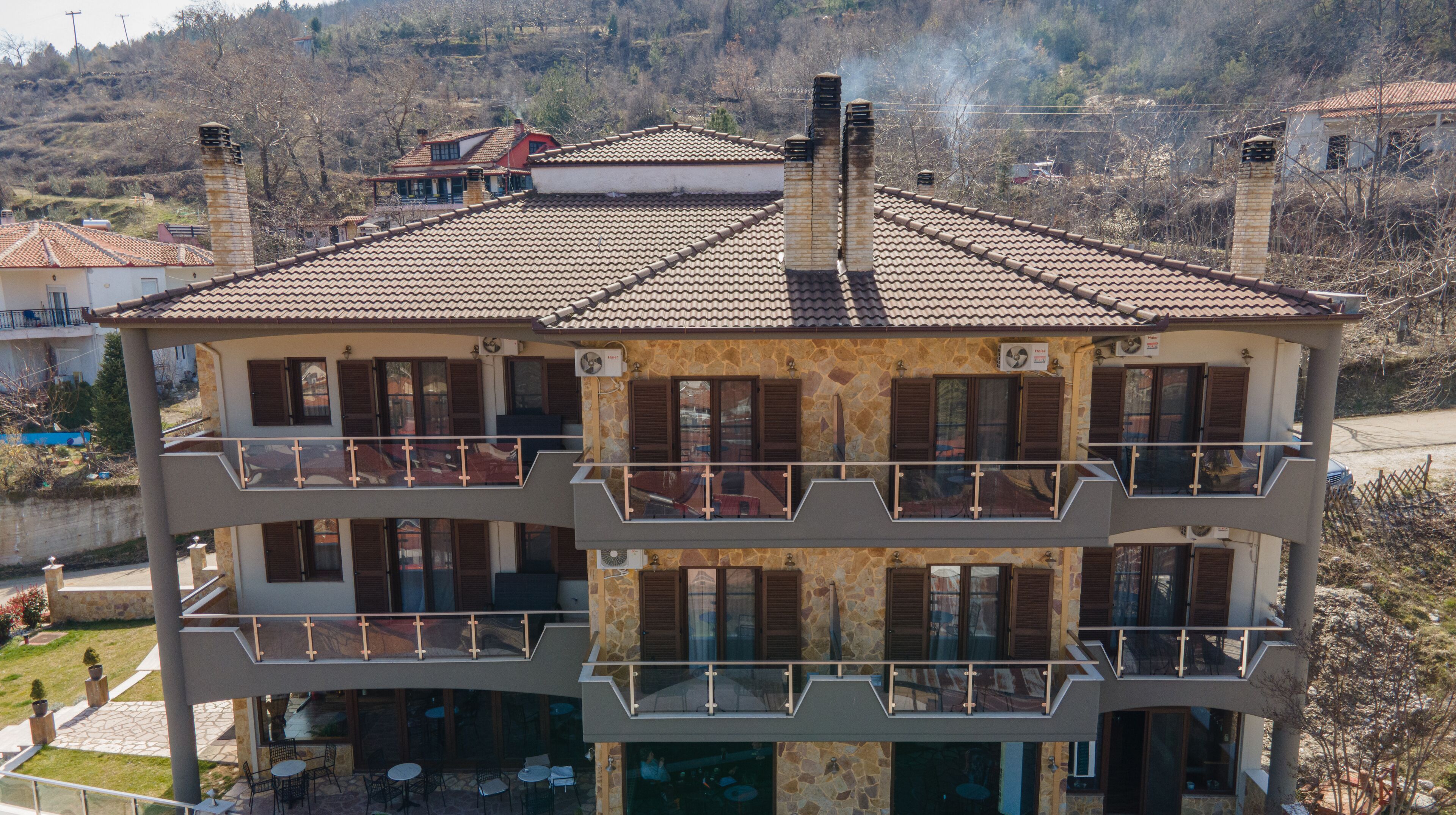 Un edificio de varios pisos con balcones, fachada de piedra y tejado de tejas.