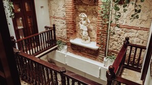 Un escalier avec un mur en briques et une statue posée sur une étagère.
