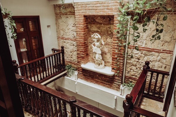 Eine Treppe mit einer Ziegelwand und einer Statue auf einem Regal.