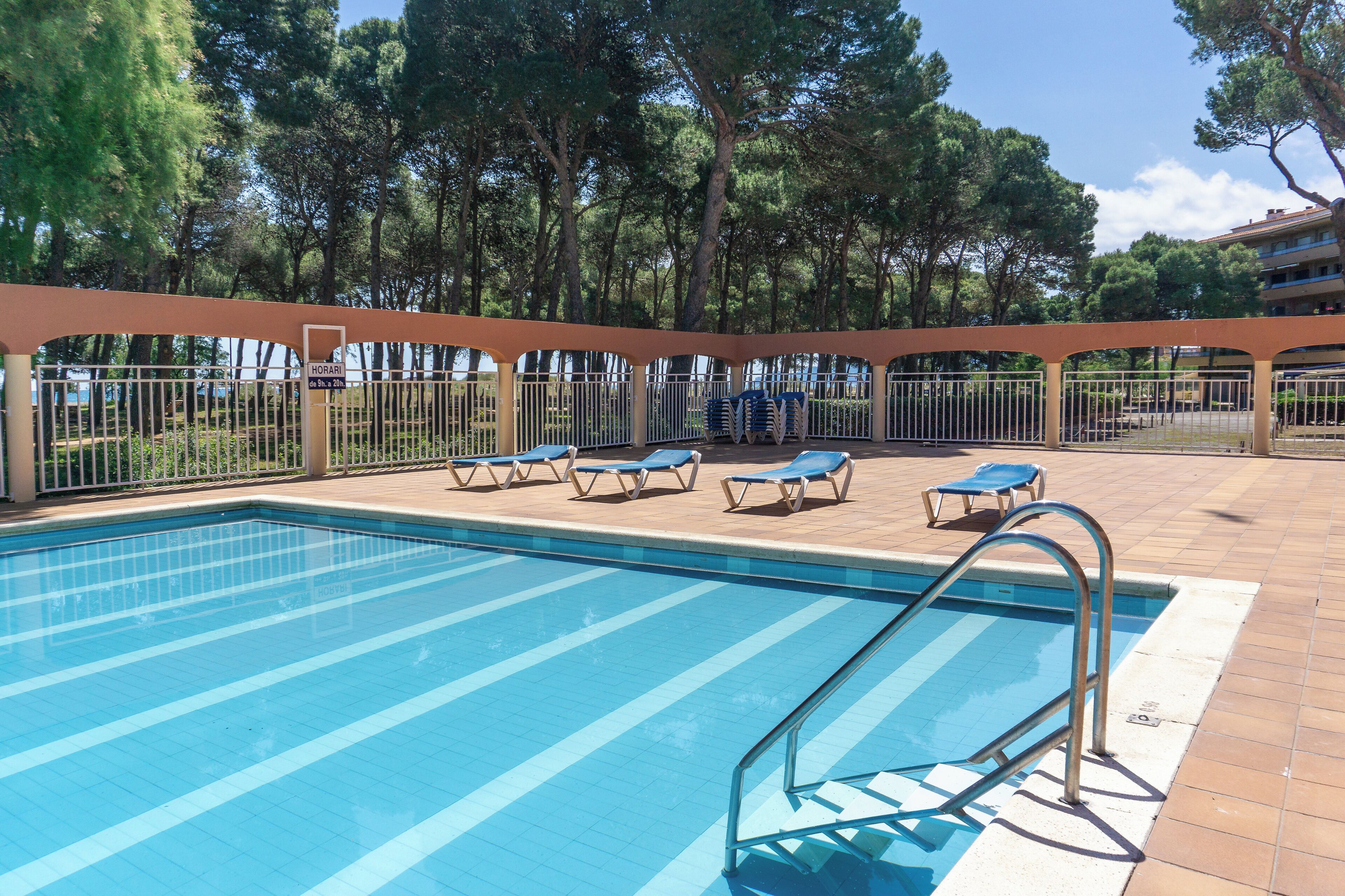 Ein Schwimmbad mit Liegestühlen und einer Pergola.