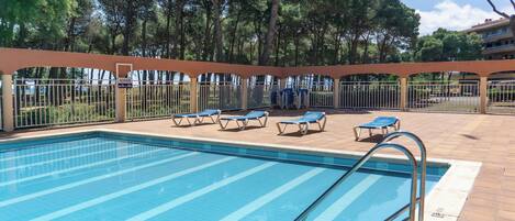 Ein Schwimmbad mit Liegestühlen und einer Pergola.