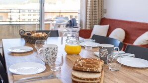 A breakfast table set with plates, cutlery, a pitcher of orange juice, and a basket of pastries. - RVApartaments La Pineda (Torroella de Montgrí)