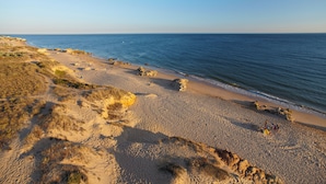 A beach with clear skies, sandy terrain, and rocky outcrops. - Wine & Books by the sea (Albufeira)