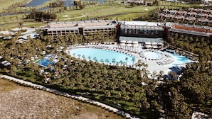 A resort with a large pool surrounded by palm trees and sun loungers. - Wine & Books by the sea (Albufeira)