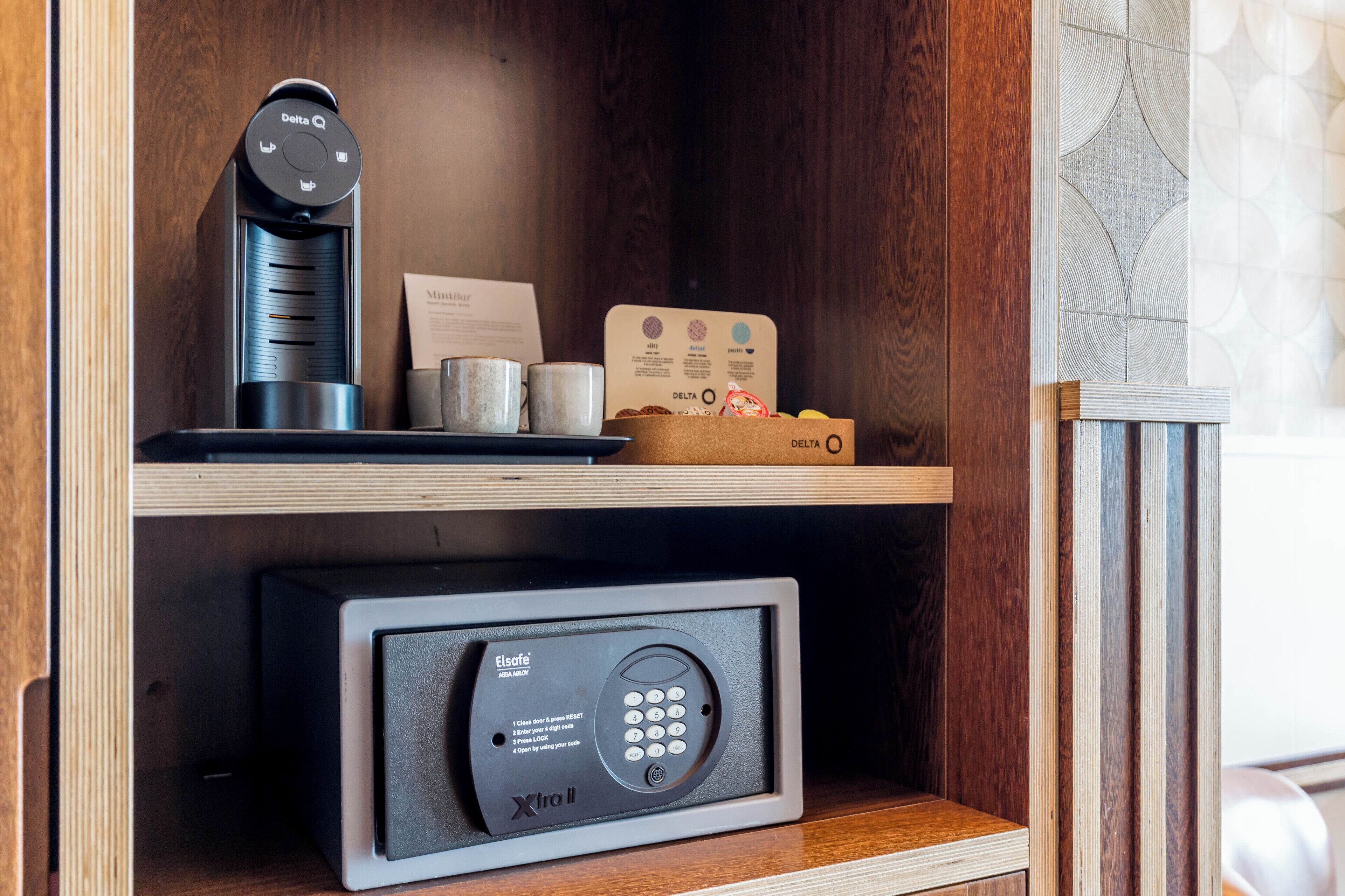 Een minibar met een koffieapparaat, kaartlezer en een beveiligde kluis.