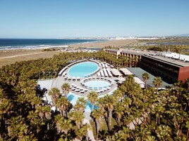 Una piscina techada, 2 piscinas al aire libre, sombrillas