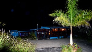 A building with a blue exterior and a palm tree in the foreground. - Hotel Quelitales (Cachi)