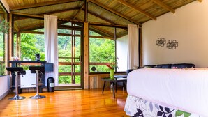A room with a bed, a desk, and a view of greenery. - Hotel Quelitales (Cachi)