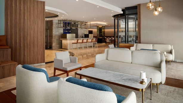 A modern hotel lobby with a seating area, a reception desk, and a bar/lounge. - Ramada Encore by Wyndham Konya Karatay (Konya)