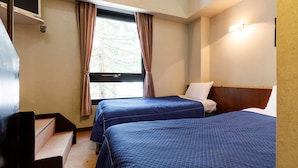 Une chambre d’hôtel avec deux lits, une fenêtre avec des rideaux, une tête de lit en bois et un luminaire fixé au mur.