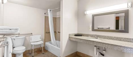 A bathroom with a toilet, shower, and sink.