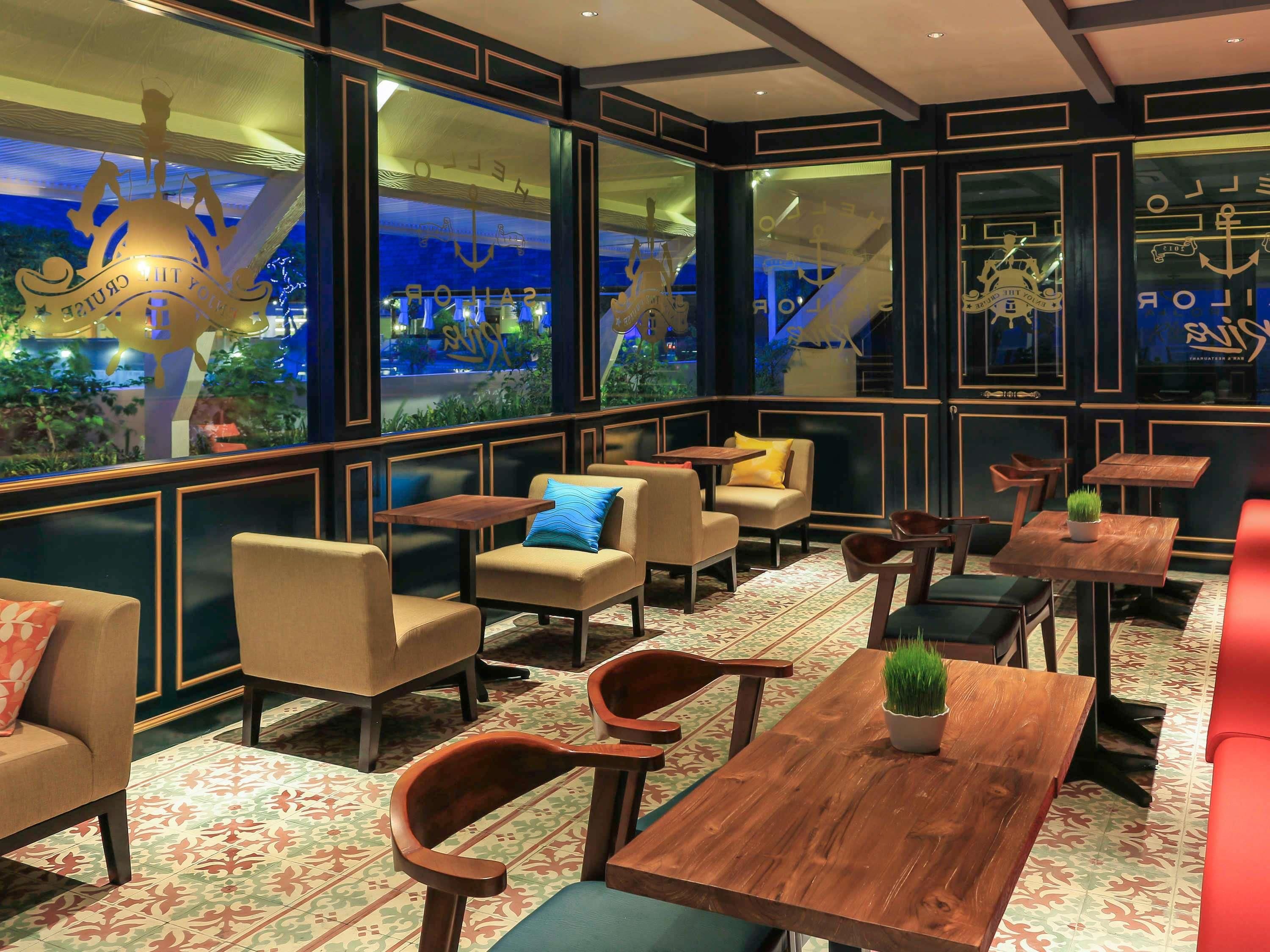 Un restaurant à thème maritime, doté de grandes fenêtres, de tables en bois et de sièges confortables.