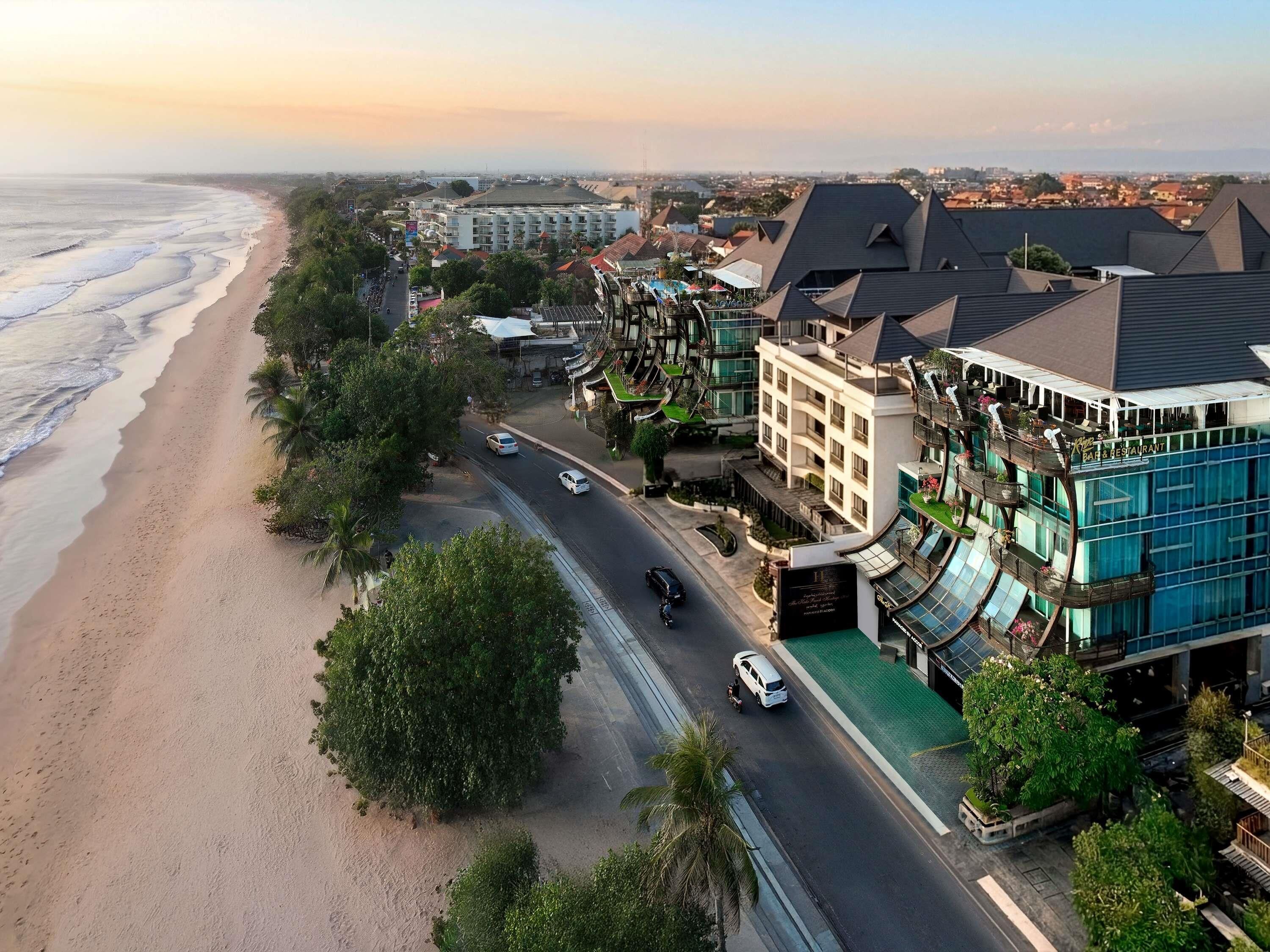 A coastal hotel with a beachfront view, multiple floors, and a restaurant on the ground level.