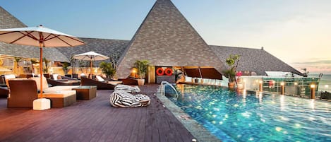 Una piscina al aire libre, sombrillas