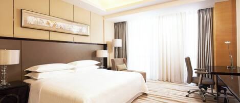 Habitació d'hotel amb un llit gran, un escriptori, una cadira i una làmpada.