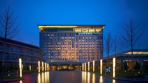 Un hotel moderno con una entrada amplia y una fachada bien iluminada.