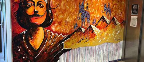 A mural with abstract figures and a mountain landscape.