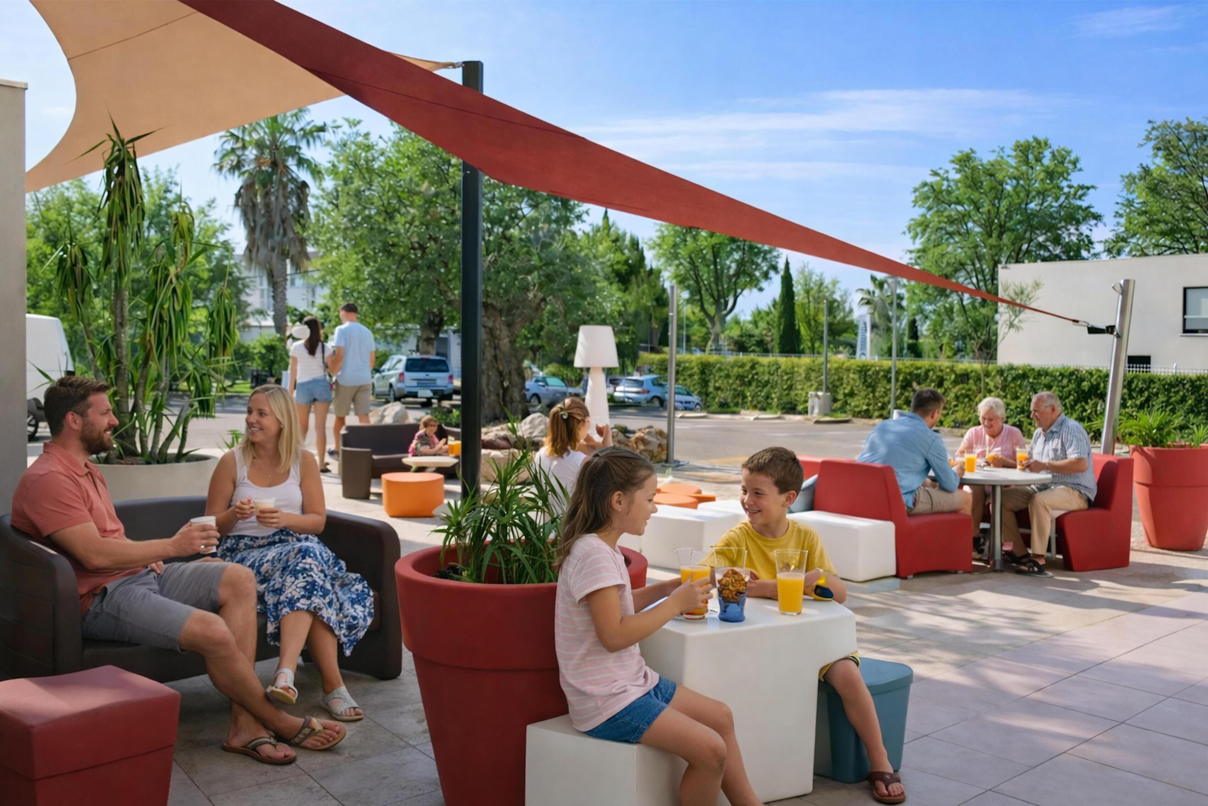 A patio area with outdoor seating and a large umbrella providing shade.