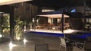 Una piscina al aire libre, sombrillas, sillones reclinables de piscina