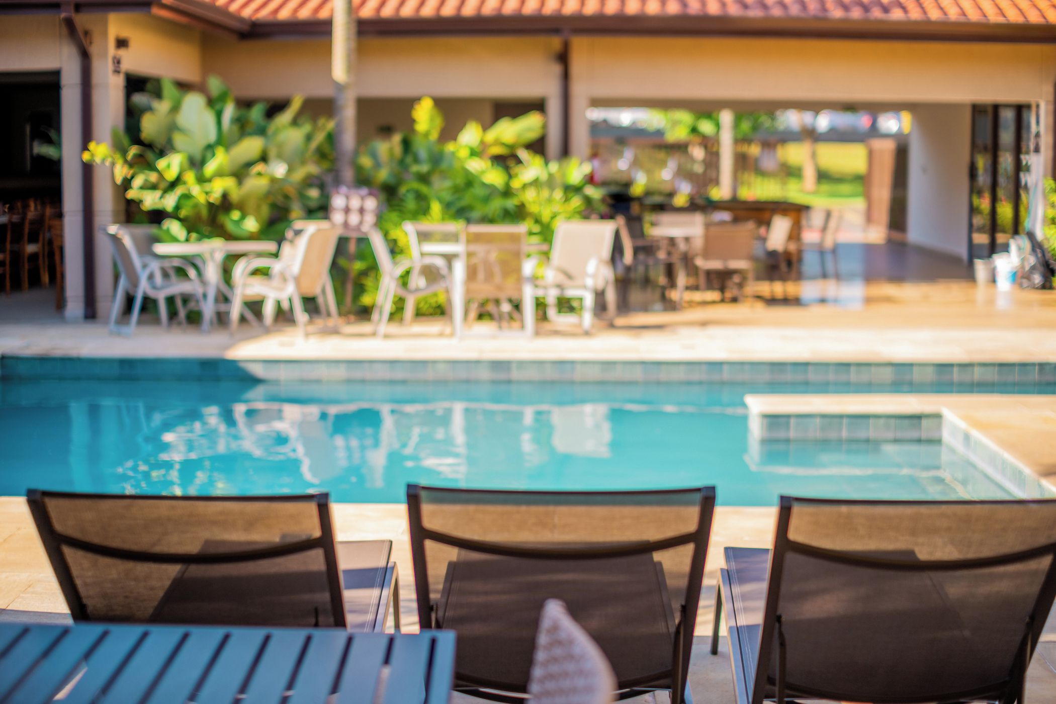 A poolside area with lounge chairs and a pool.