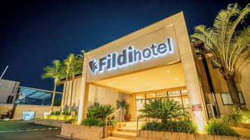 Entrada de um hotel com uma placa indicando 'Fildihotel' e uma escadaria que leva à entrada.