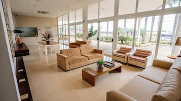 A spacious living area with a sofa set, a coffee table, and a dining table.