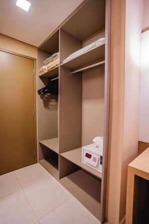 Un dressing avec des étagères, une tringle et un meuble de rangement.